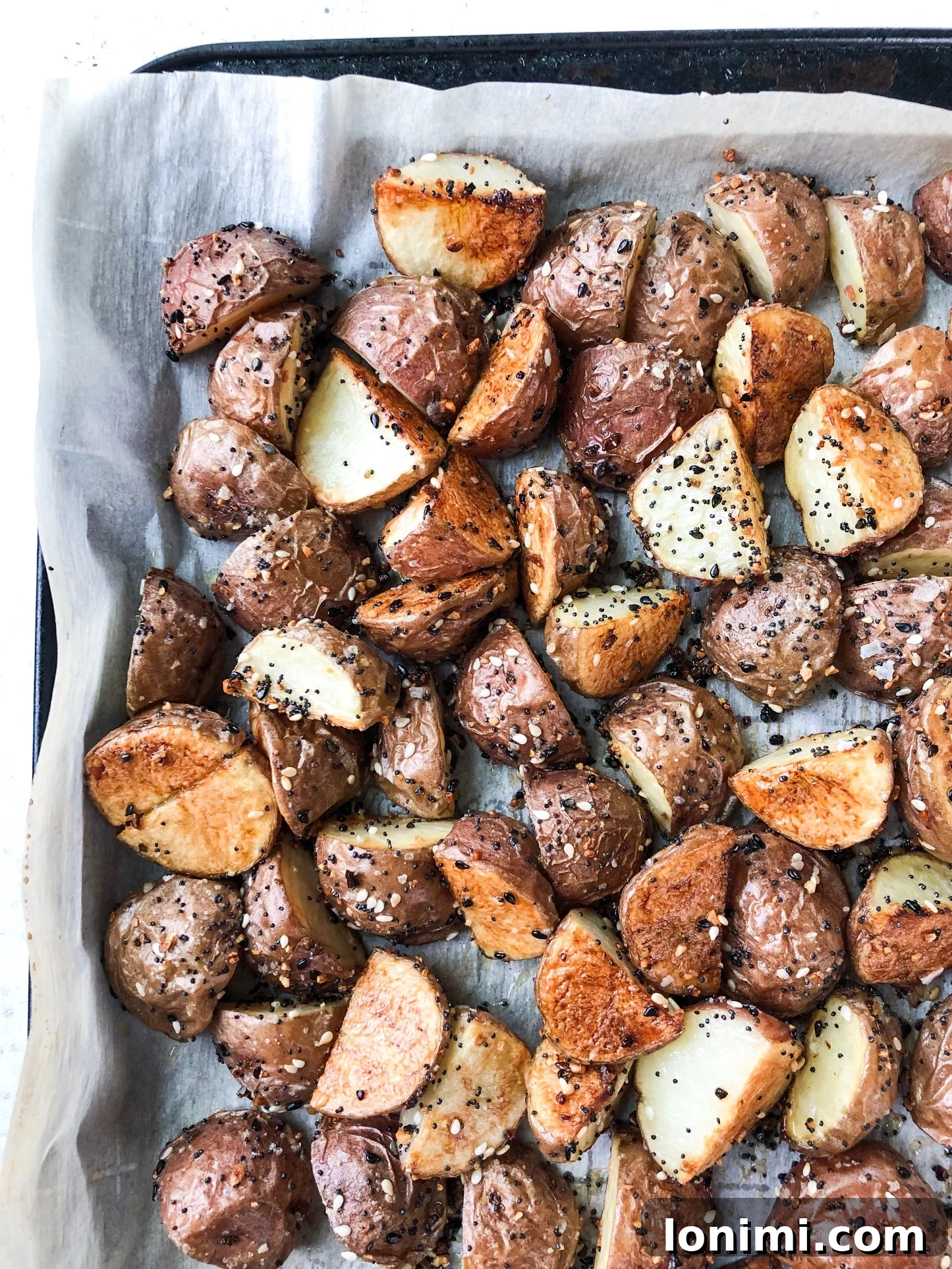 Roasted Potato Perfection 2 Crispy Everything Roasted Potatoes on a white baking sheet