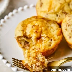 Maple Pancake Breakfast Muffins 11 McGriddle Muffins on a plate with syrup and a fork taking a bite out