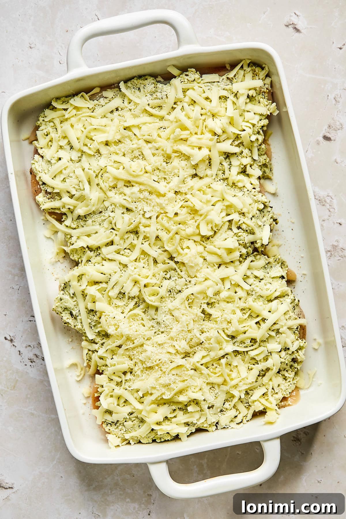 Chicken covered with cheese before going into the oven