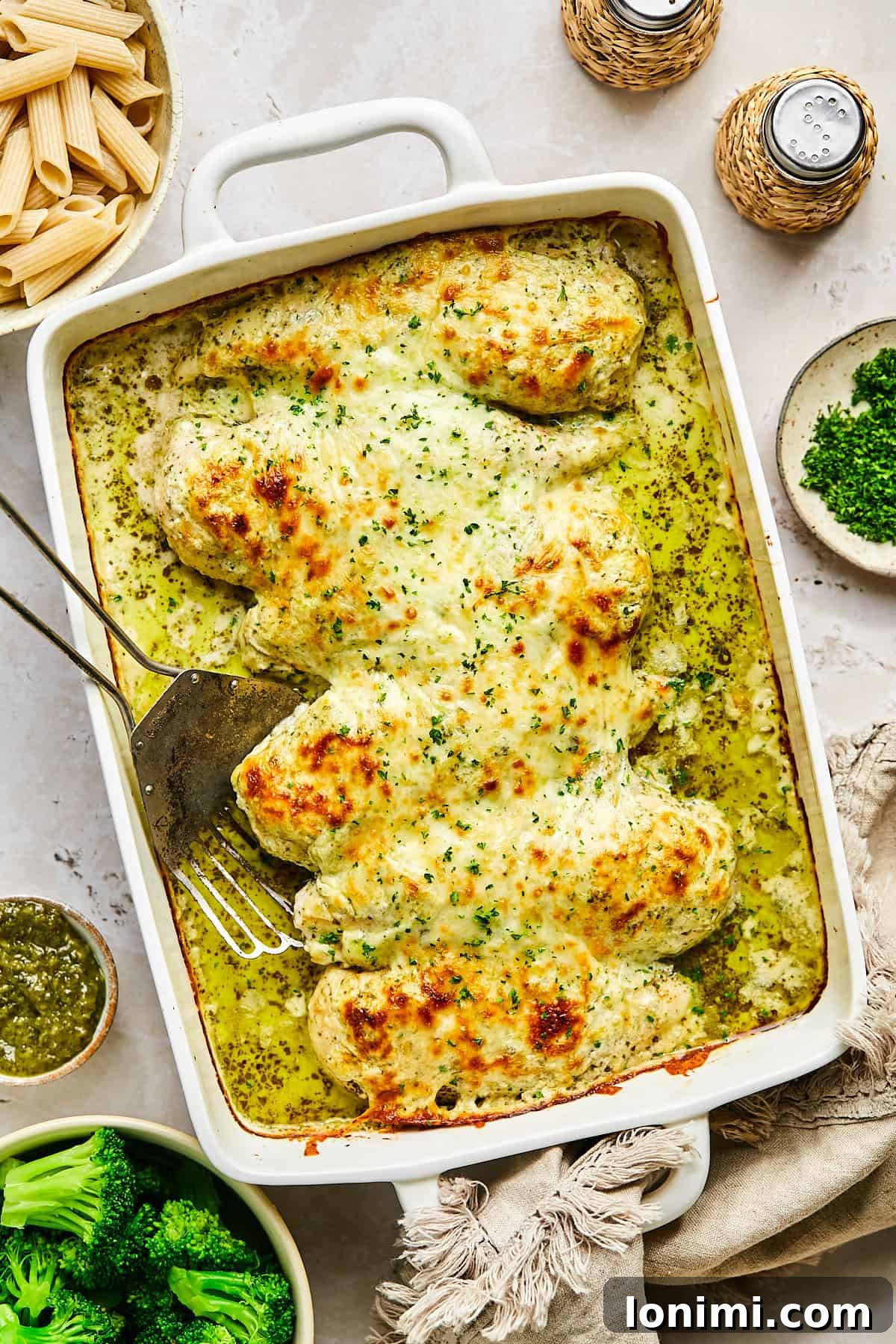 Baked pesto chicken with golden cheese topping and visible bubbling edges
