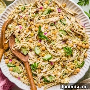 high protein Jennifer Aniston Salad in a bowl surrounded by a pink napkin and ingredients