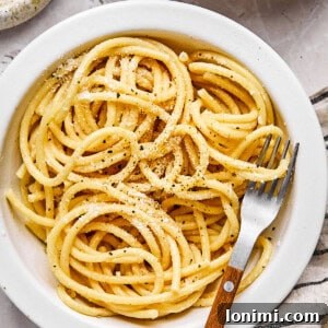 gluten free bucatini cacio e pepe in a white bowl