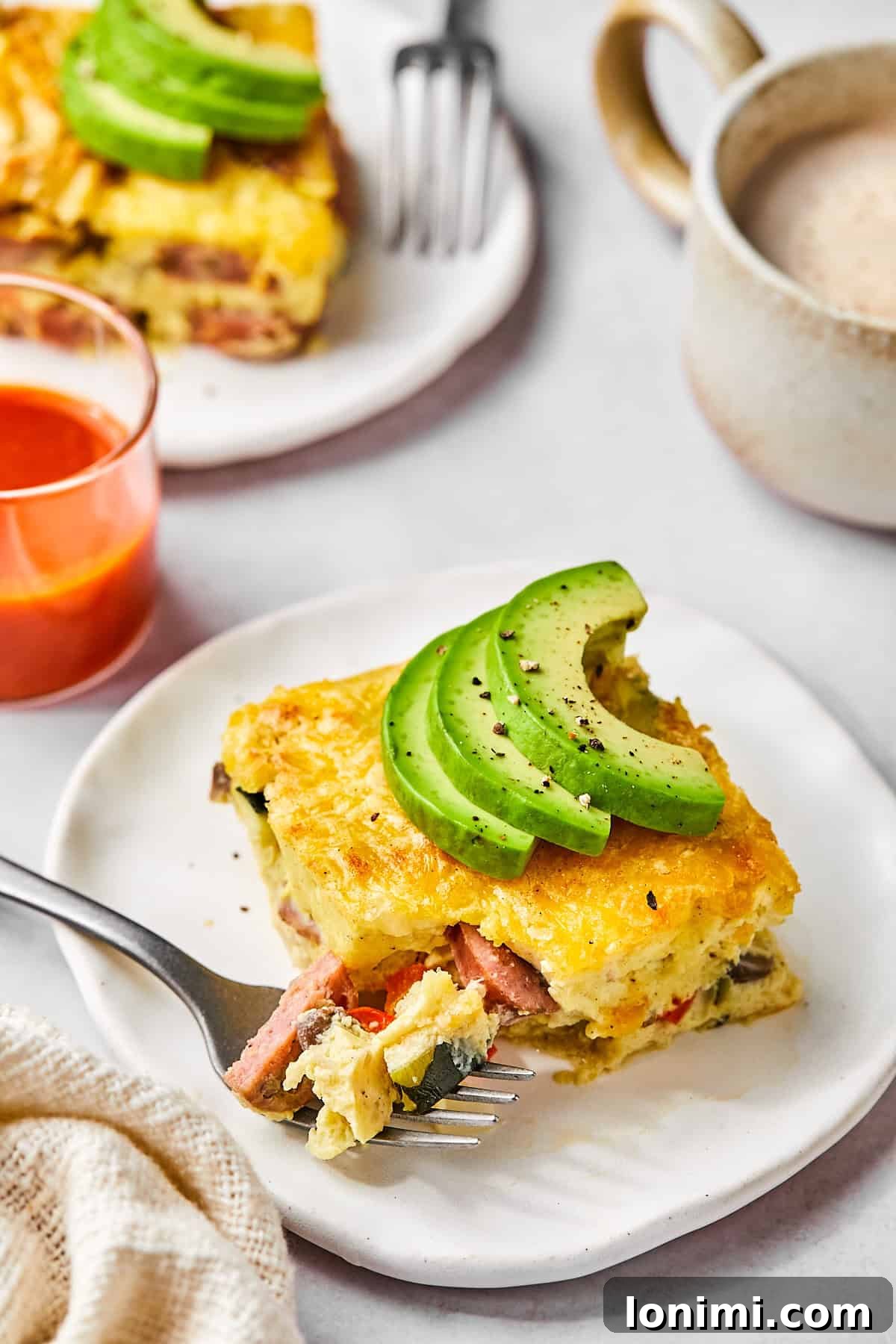 Sliced squares of egg bake on a serving plate topped with avocado 