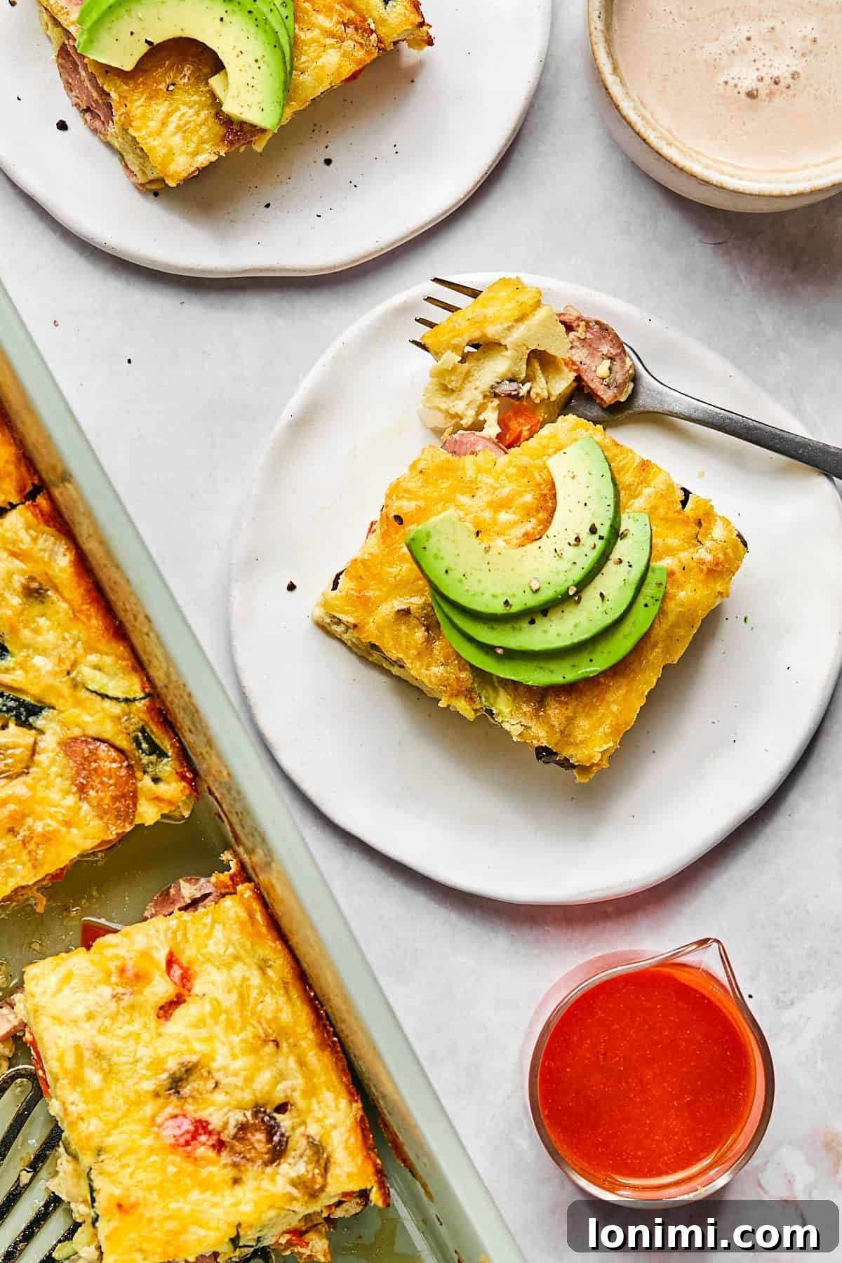 Close-up of a plated slice of cottage cheese egg bake garnished with avocado