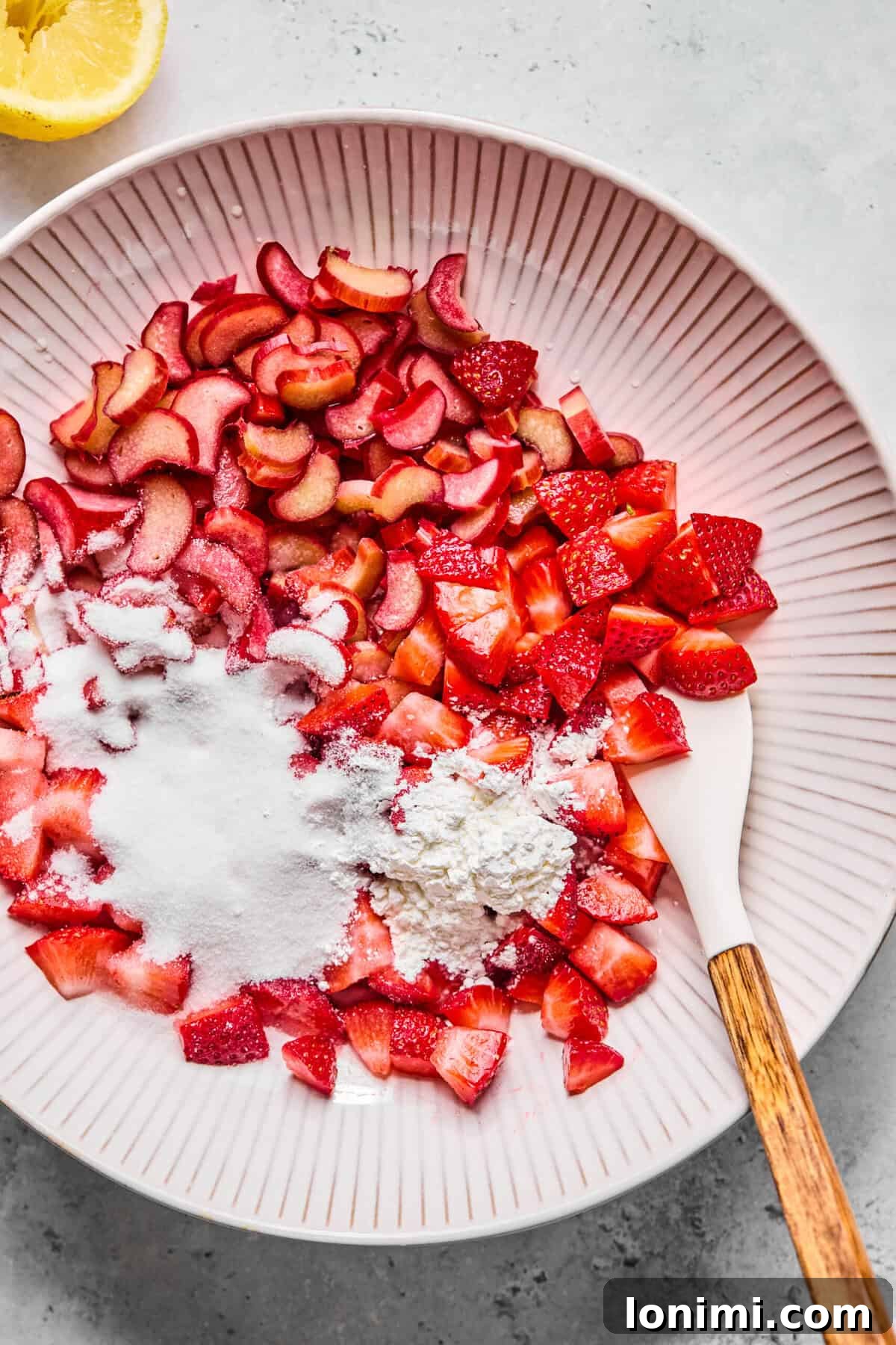 Bowl of diced strawberries and rhubarb tossed with sugar, lemon juice, and arrowroot powder