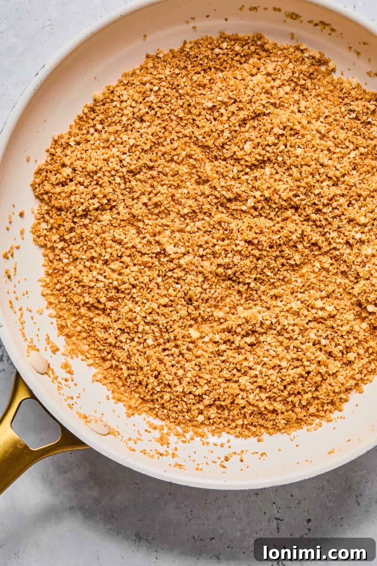 Close-up of golden, toasted gluten-free panko breadcrumbs sizzling gently in a medium-sized pan on the stove, ready for the fried pickle dip.