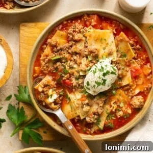 gluten free lasagna soup in 3 bowls with a dollop of ricotta cheese and parsley on top