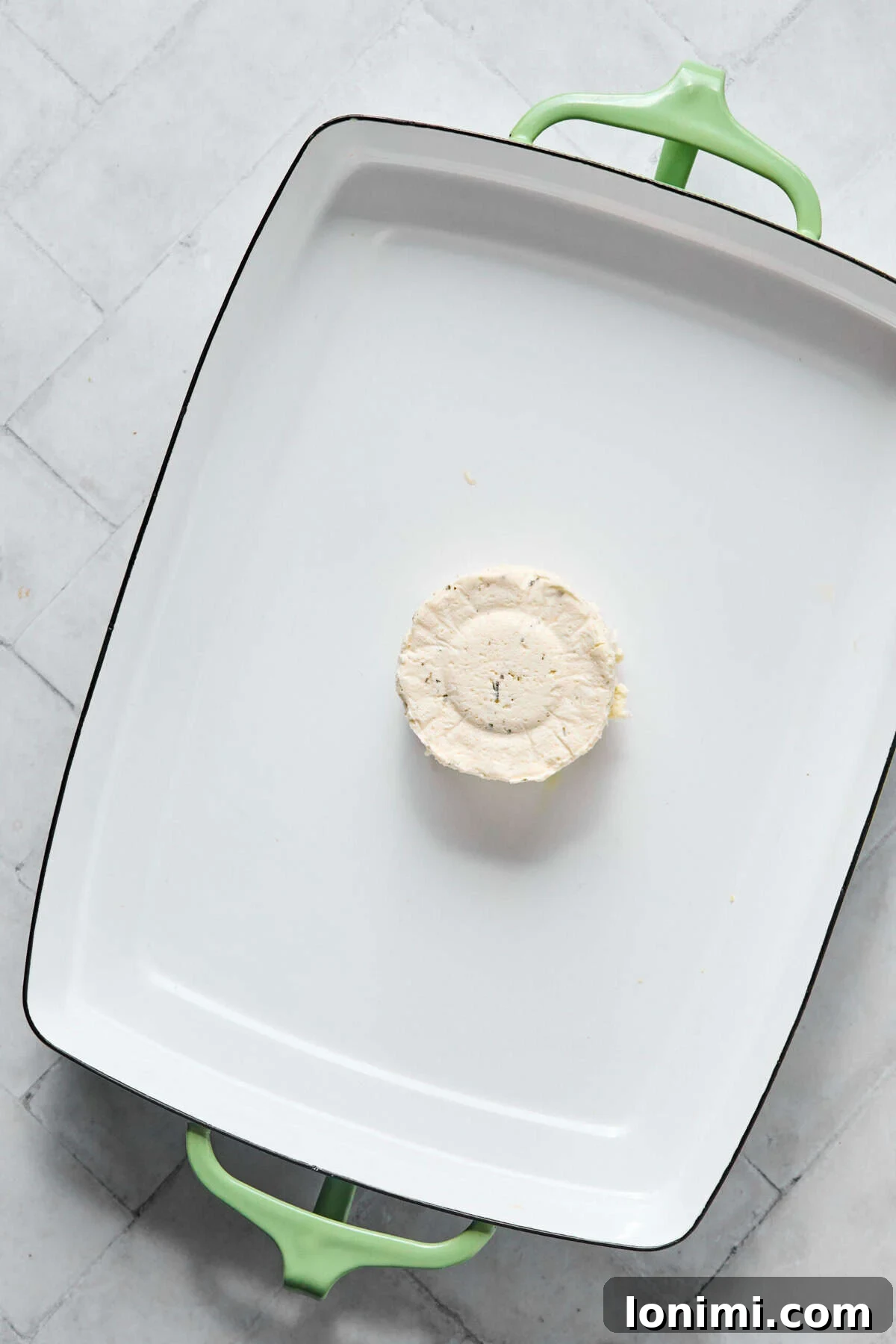 Boursin cheese placed in the center of a baking dish before baking.