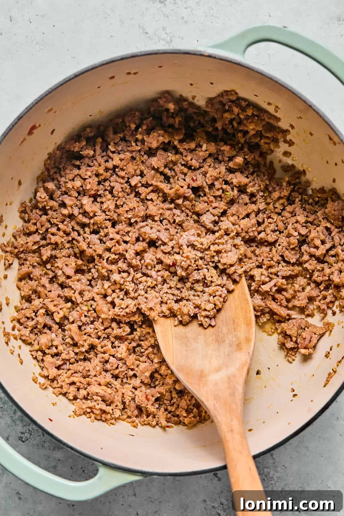 Browning Italian sausage in a large pot with olive oil for butternut squash lasagna soup.