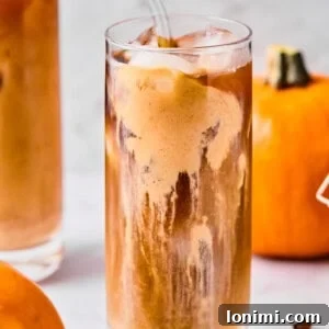 Homemade Protein Pumpkin Cold Foam Perfection 10 A captivating image of protein pumpkin cold foam meticulously layered over cold brew coffee in a clear glass, inviting indulgence.