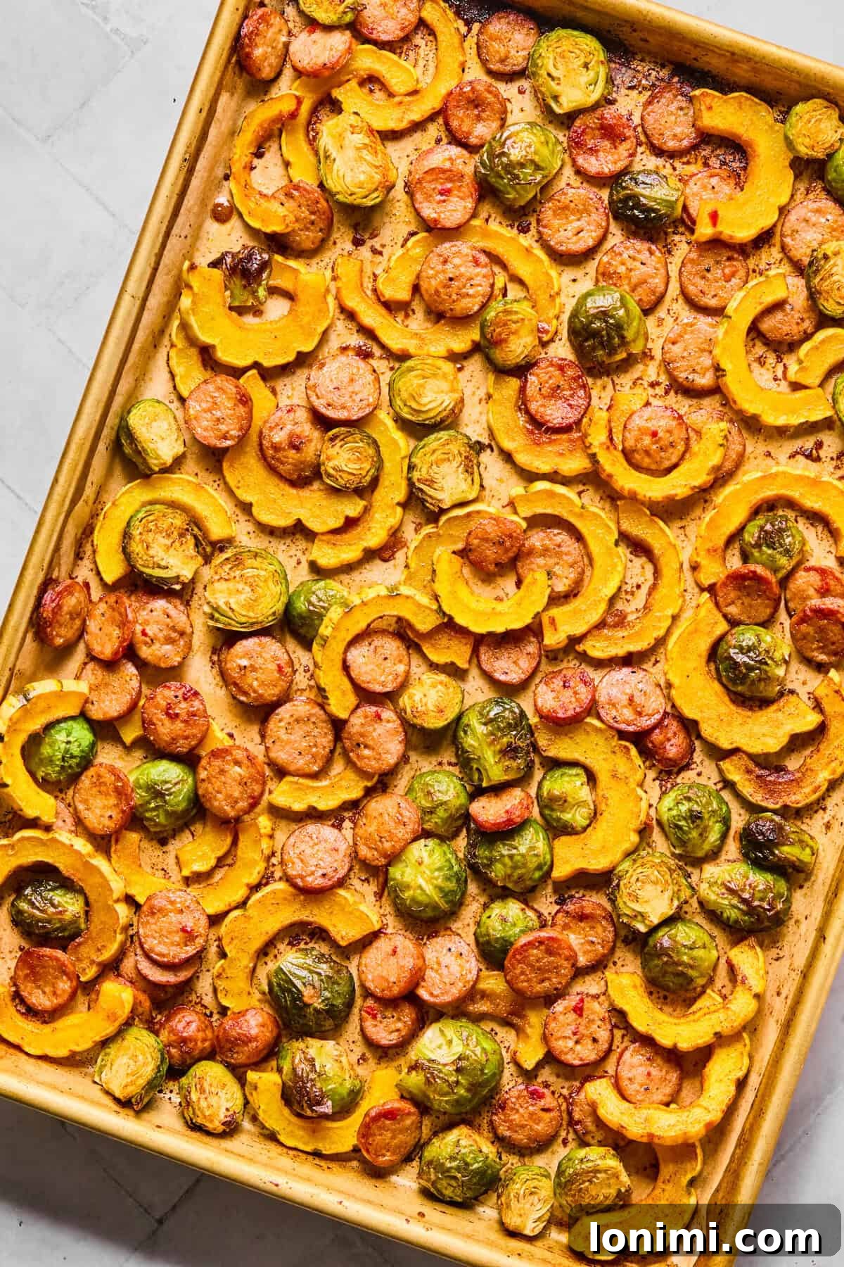 finished sheet pan delicata squash with sausage and brussels sprouts, roasted until golden and tender