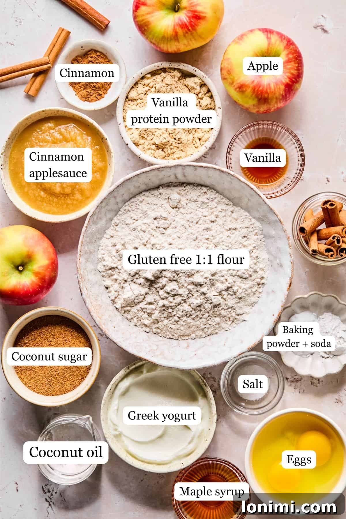 Wholesome Apple Cinnamon Protein Muffins Gluten Free 3 All the fresh ingredients for apple cinnamon protein muffins are neatly labeled and laid out on a light-colored kitchen countertop, ready for preparation.