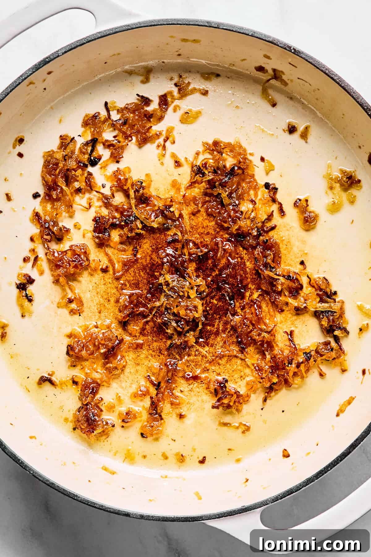 Large oven-safe skillet with deeply caramelized onions.