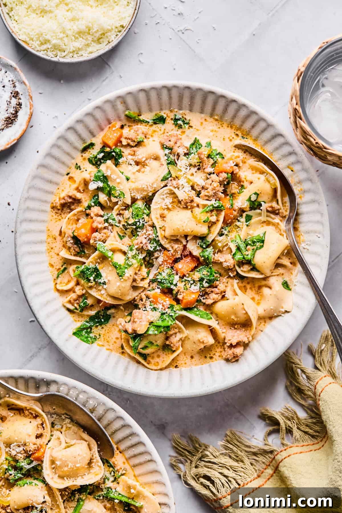 Slow Cooker Creamy Sausage Tortellini Soup 2 creamy sausage tortellini soup in a white bowl with spinach and veggies and a creamy boursin cheese sauce
