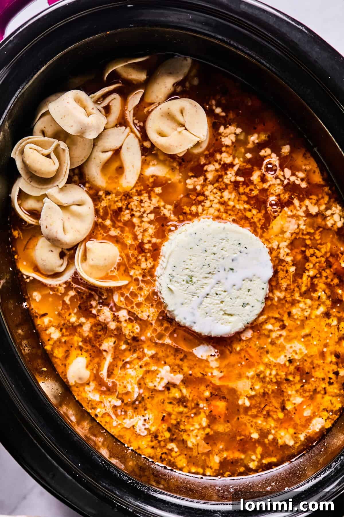 Slow Cooker Creamy Sausage Tortellini Soup 8 adding boursin cheese and tortellini to the crockpot