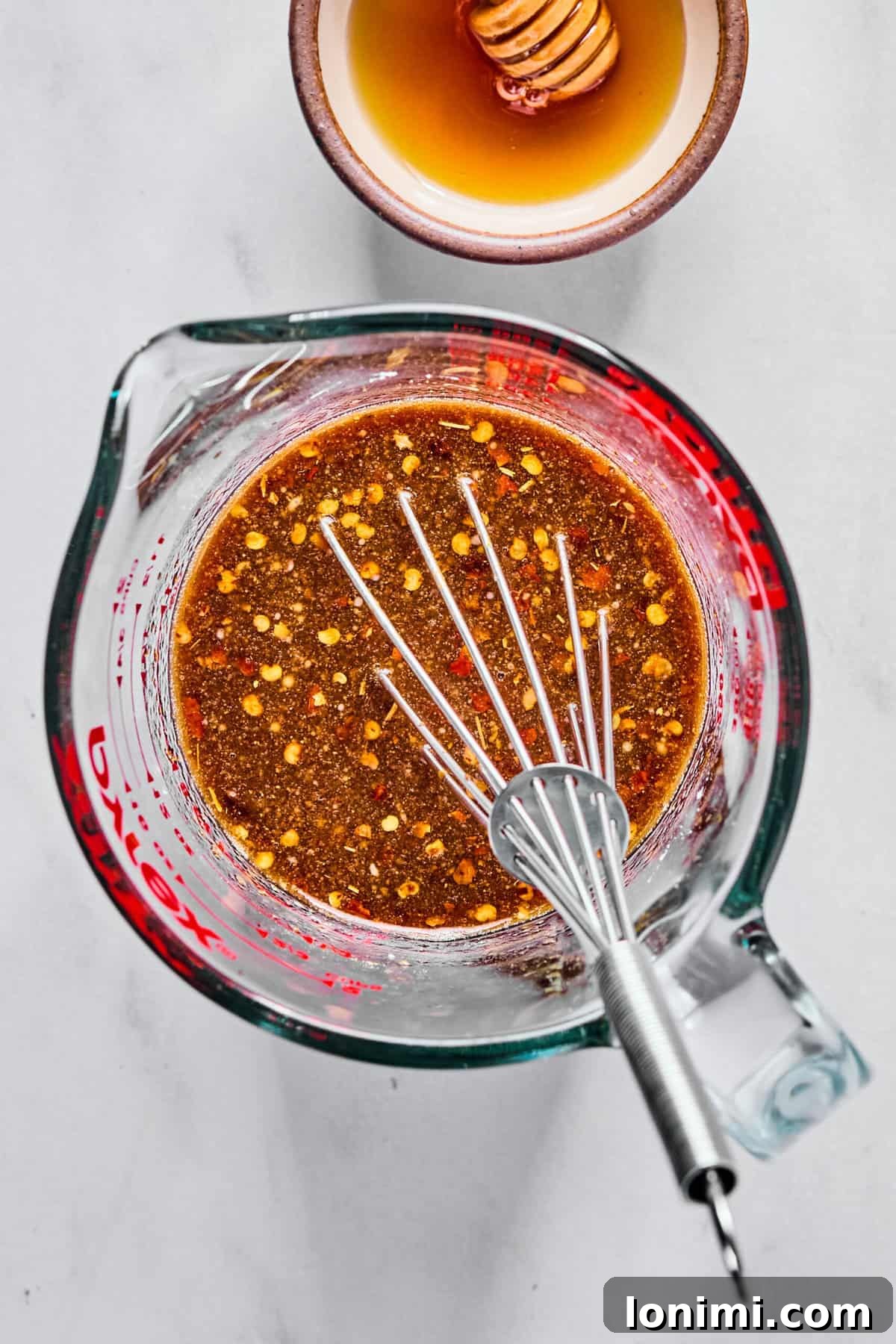 Stir fry sauce ingredients in a glass measuring cup whisked together.