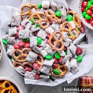 gluten free reindeer chow / Christmas Muddy Buddies in a holiday tin with tissue paper surrounded by mix-ins