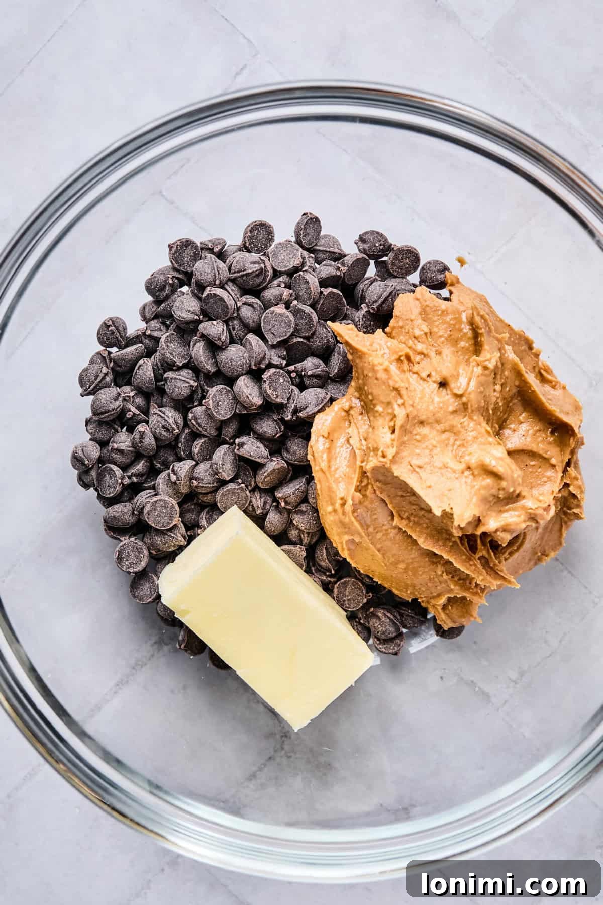 Chocolate chips, peanut butter, and butter in a microwave-safe bowl, ready to be melted.