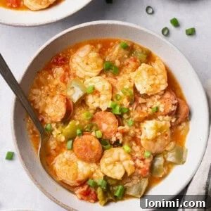 Instant Pot Jambalaya Soup in a bowl with a spoon topped with green onions