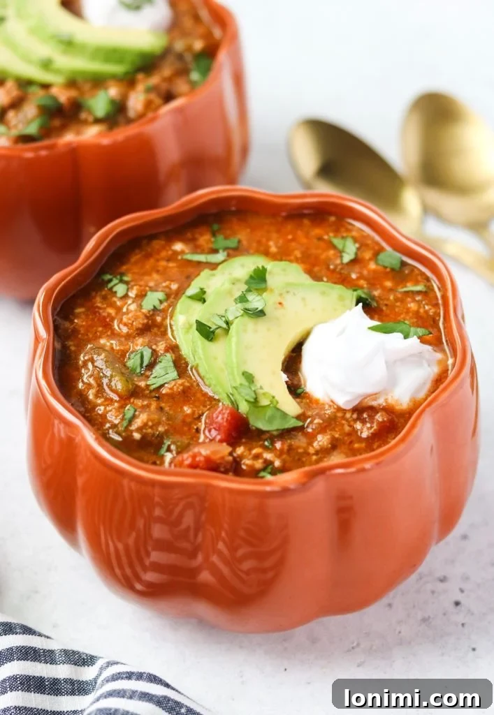 25 Hearty Whole30 Soups, Stews, and Chilis 11 Savory Instant Pot Pumpkin Turkey Chili, perfect for fall and Whole30 compliant, garnished with fresh herbs.