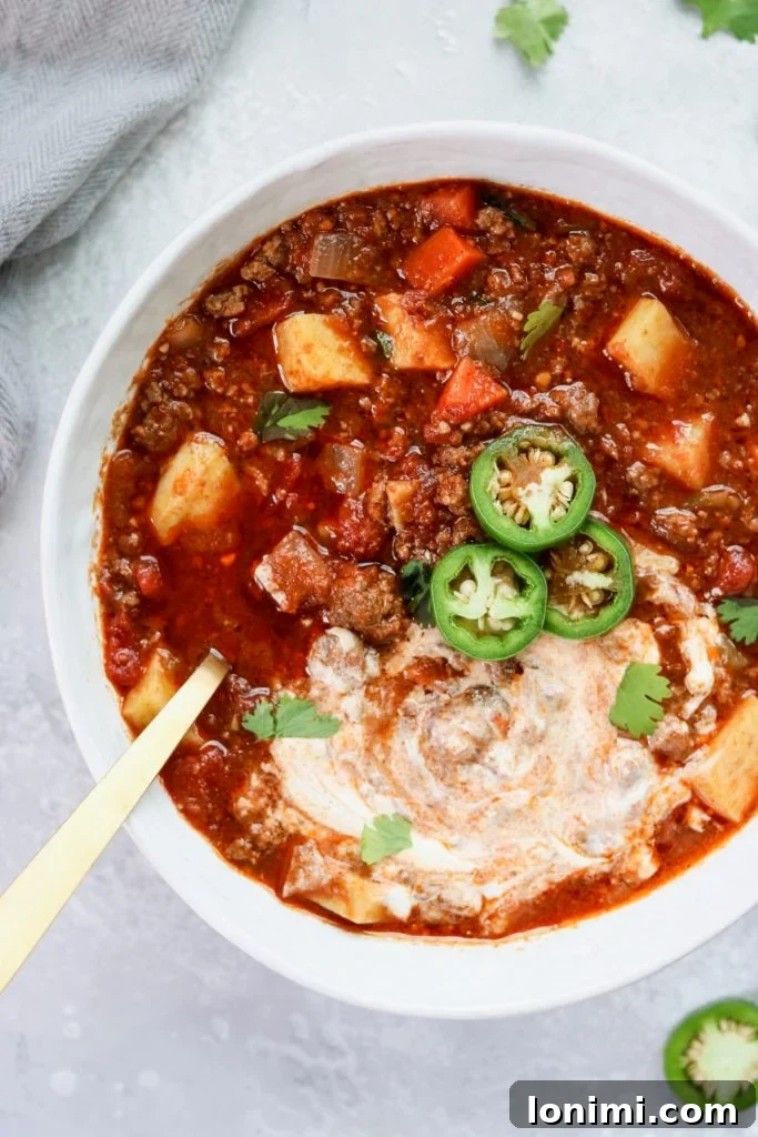 25 Hearty Whole30 Soups, Stews, and Chilis 13 A hearty bowl of Slow Cooker Sweet Potato Chili, Whole30 compliant and perfect for meal prep, garnished with avocado.