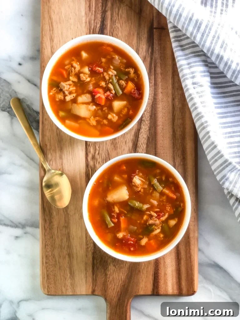 25 Hearty Whole30 Soups, Stews, and Chilis 6 A steaming bowl of Whole30 Maryland Crab Soup, brimming with fresh crab meat, corn, and a colorful medley of vegetables.