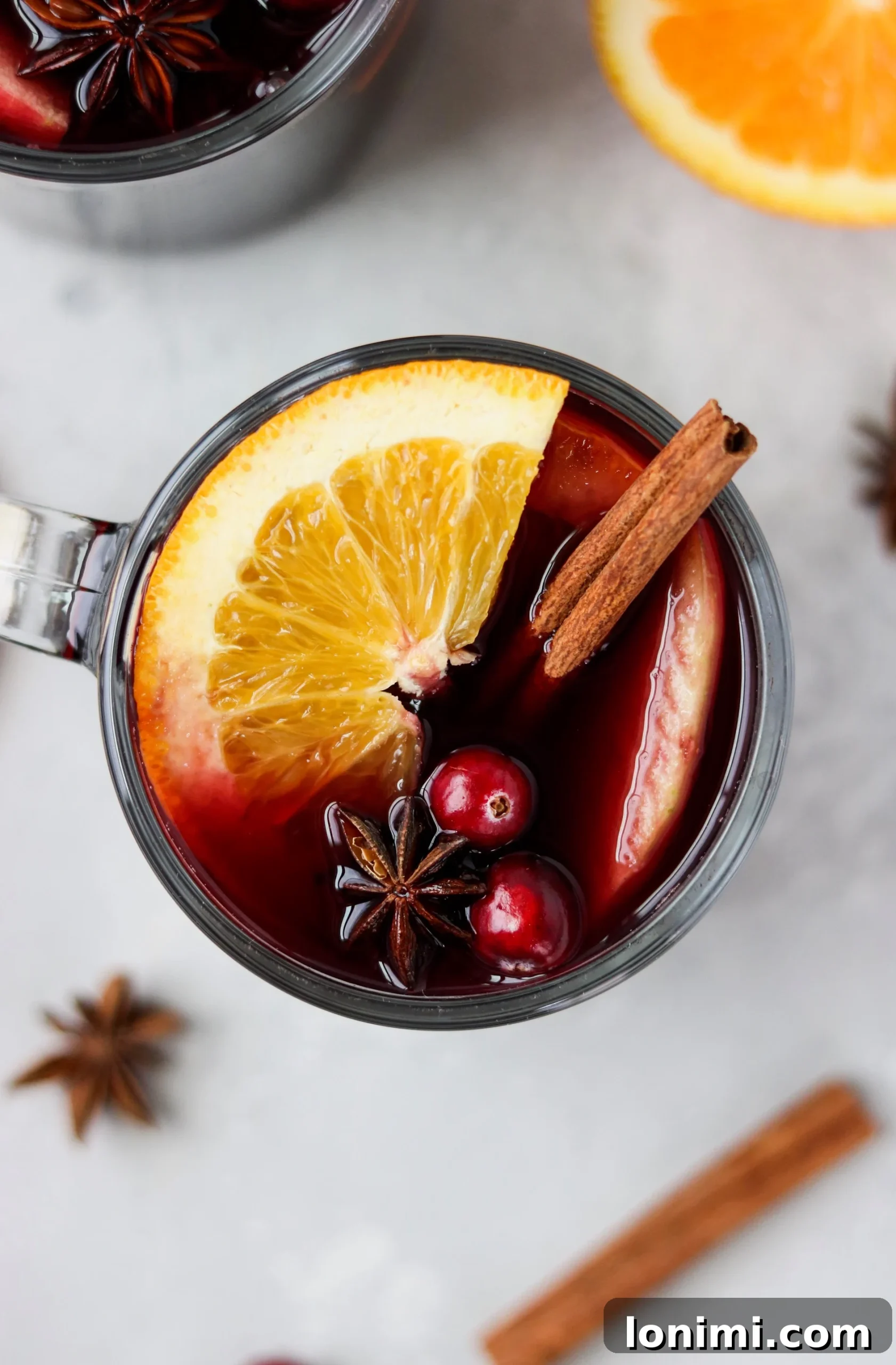 Close-up of mulled wine ingredients, including orange slices, star anise, and cinnamon sticks.