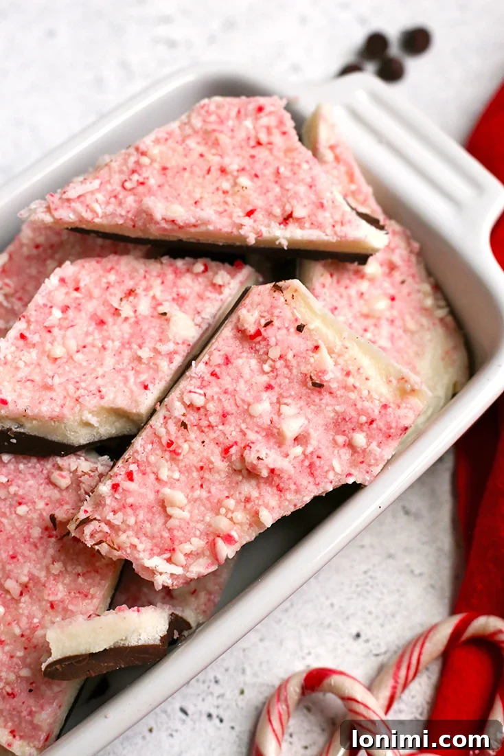 Close-up of Paleo Peppermint Bark, showcasing layers of dark and white chocolate with crushed peppermint candy.