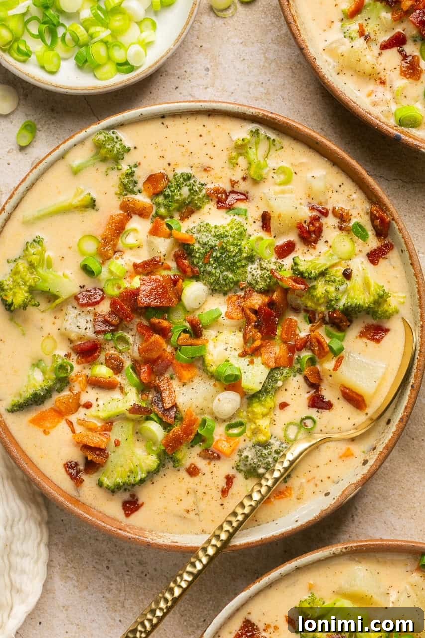 an overhead shot of loaded baked potato soup in a bowl, garnished with bacon and green onions
