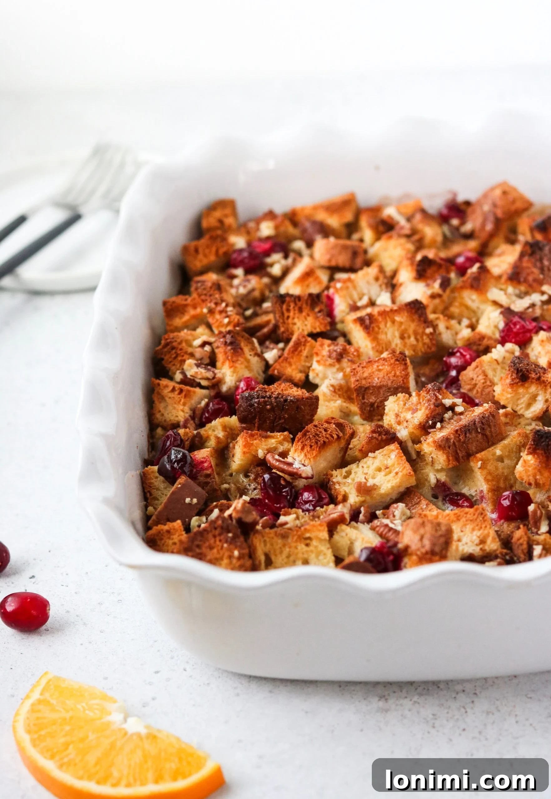 Zesty Orange Cranberry Overnight French Toast Bake Gluten and Dairy Free 4 Overhead shot of a slice of Orange Cranberry French Toast Casserole on a plate with maple syrup drizzle.