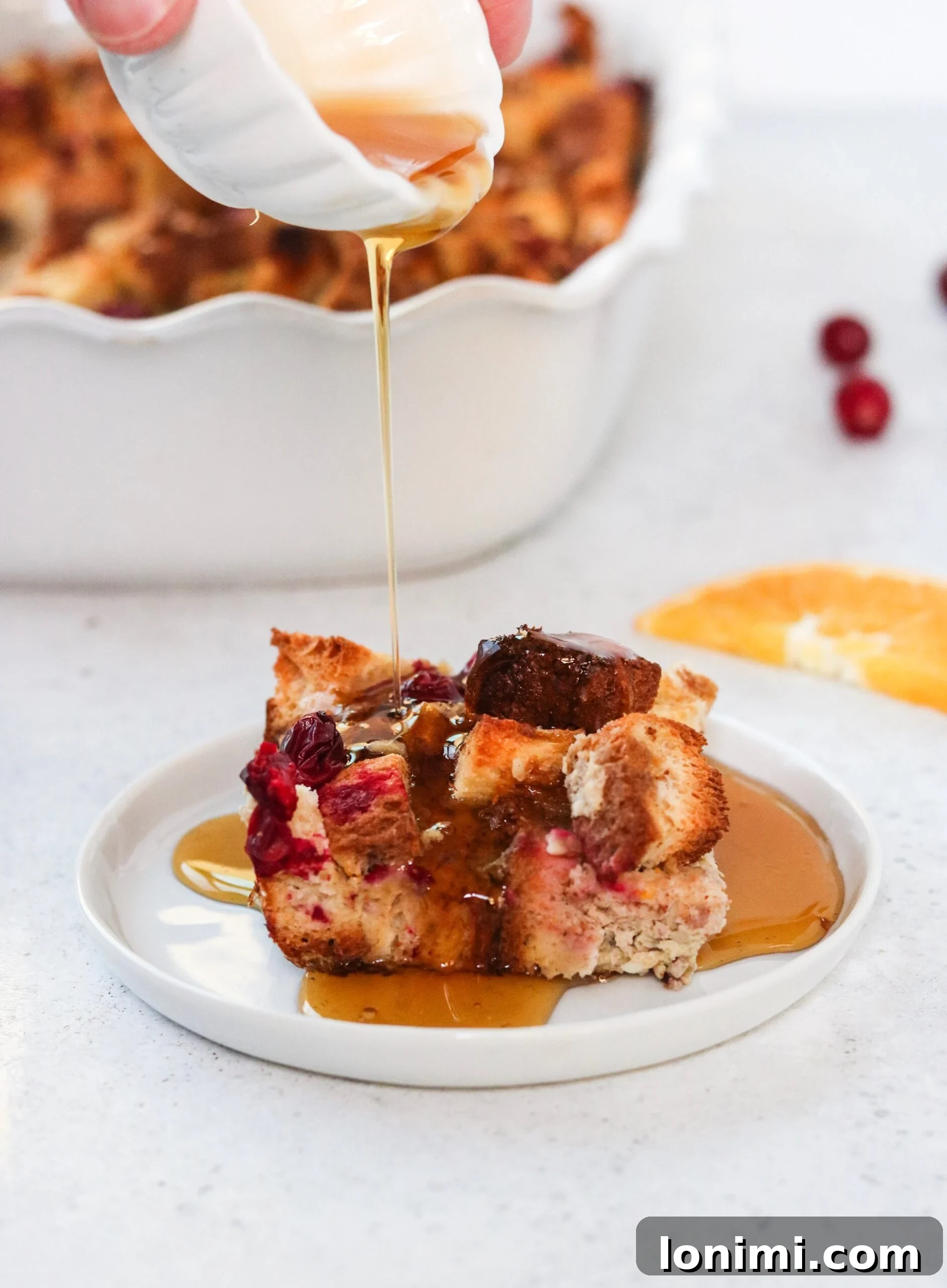 Zesty Orange Cranberry Overnight French Toast Bake Gluten and Dairy Free 6 Overnight French toast casserole in a baking dish, ready for the oven with pecan topping.