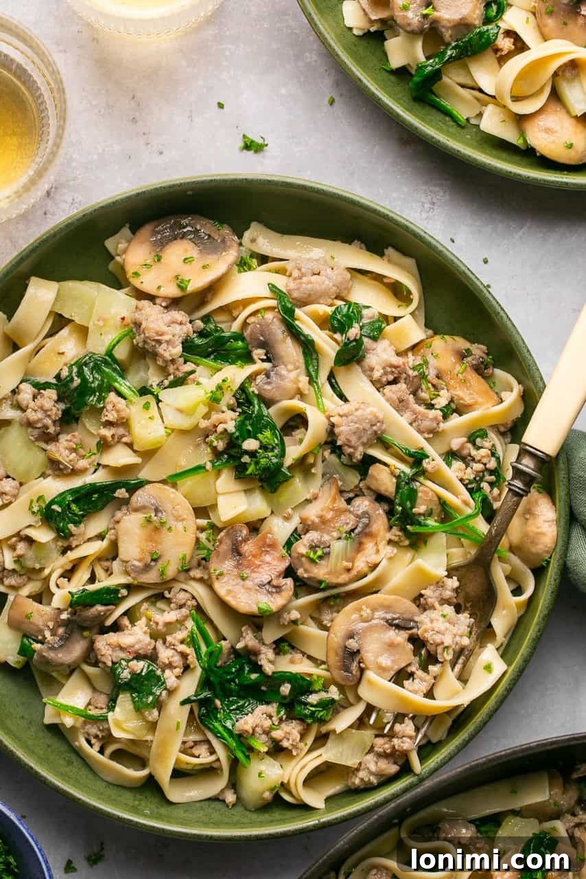 Quick and Flavorful Gluten-Free Sausage and Fennel Pasta 2 A close-up shot of gluten-free sausage and fennel pasta garnished with fresh spinach and mushrooms in a rustic bowl, ready to be enjoyed.