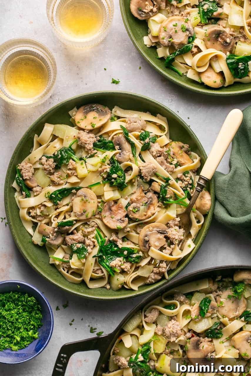 Quick and Flavorful Gluten-Free Sausage and Fennel Pasta 6 Two gray bowls brimming with gluten-free sausage and fennel pasta, generously garnished with fresh parsley, presented on a light-colored surface.