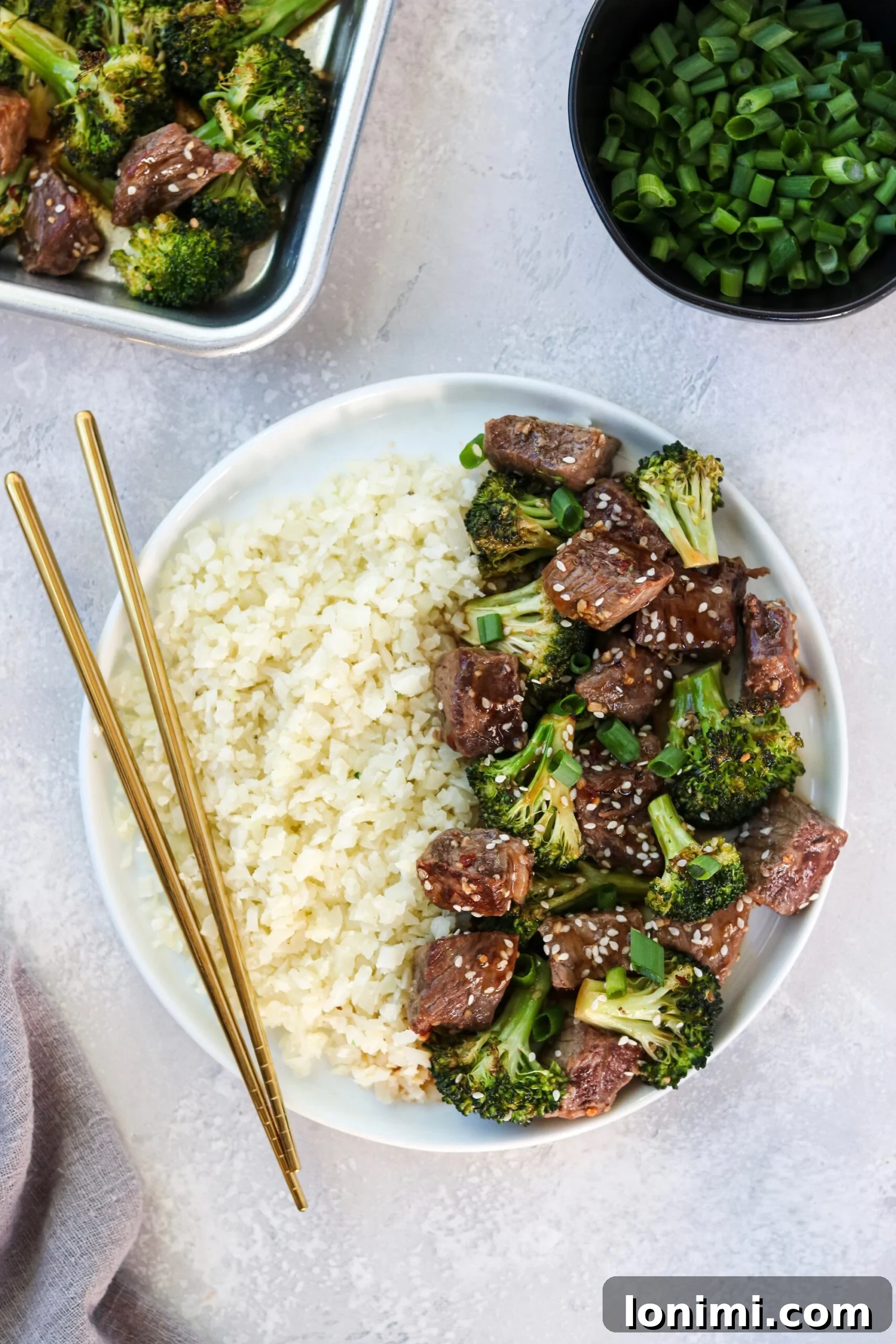 Close-up of cooked Sheet Pan Beef and Broccoli, garnished with sesame seeds.