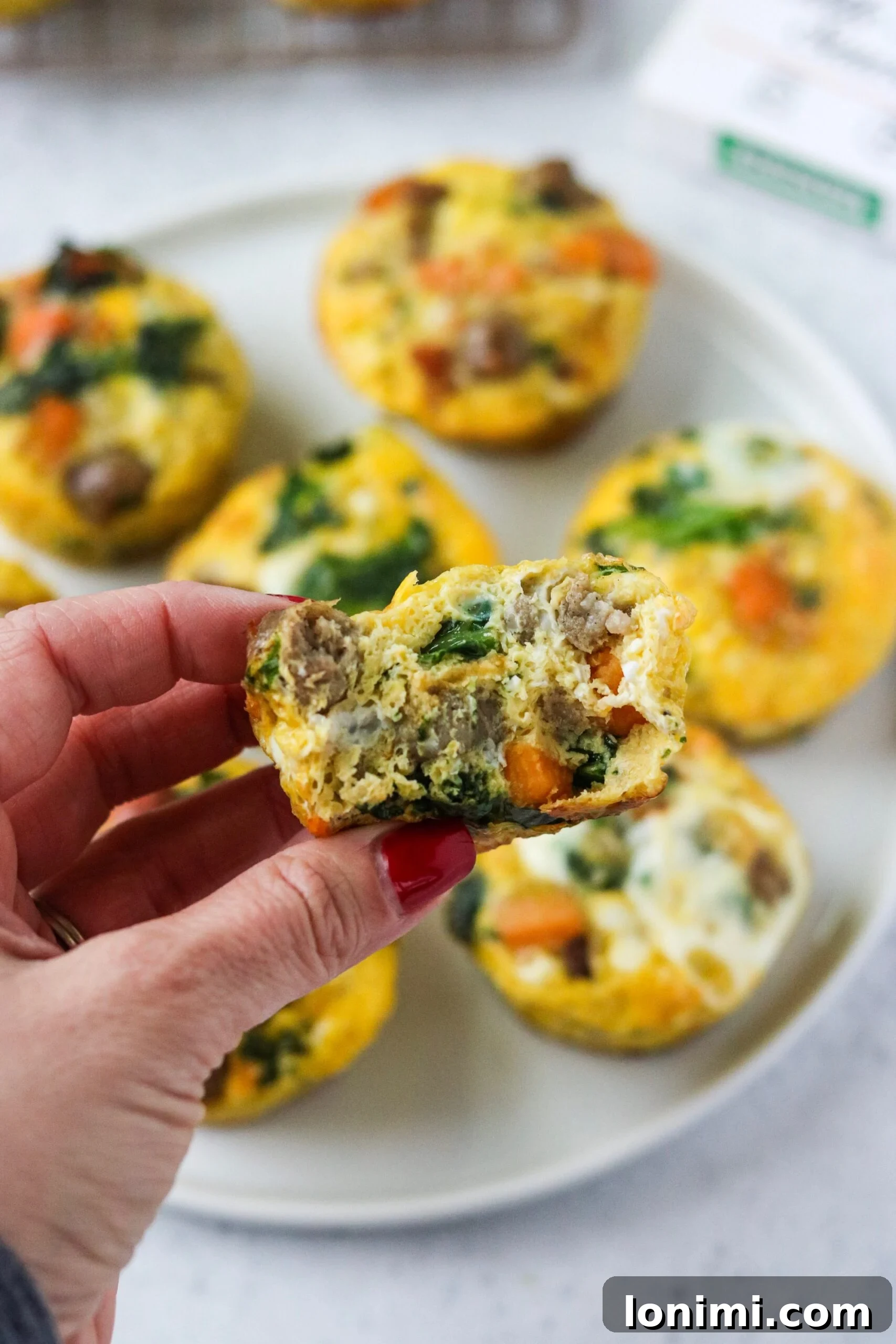 Several sausage, sweet potato, and kale egg cups arranged artfully on a plate