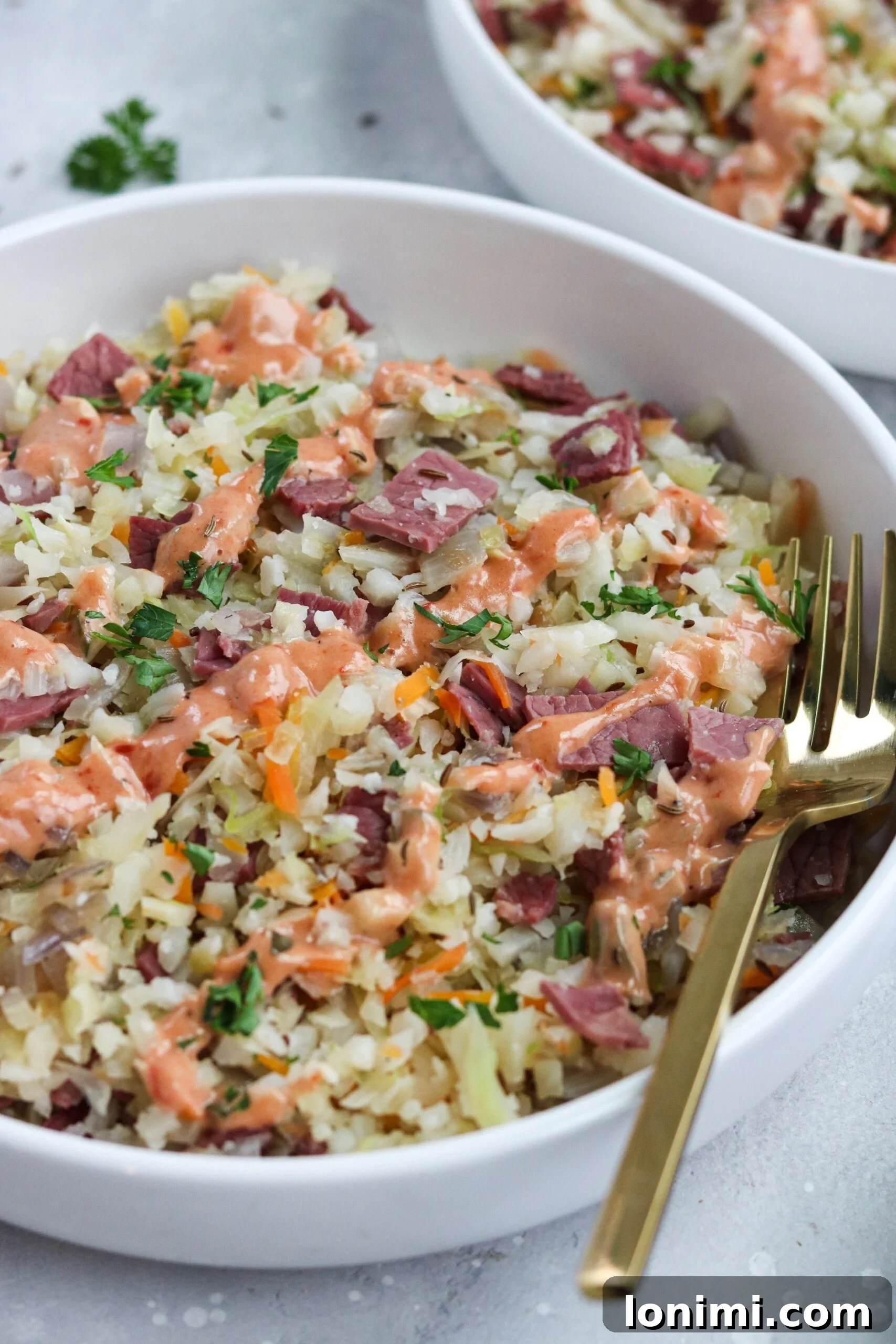 Keto Paleo Reuben Bowl 4 Ingredients for Reuben in a Bowl laid out: corned beef slices, fresh cabbage, red onion, cauliflower rice, and dressing components.