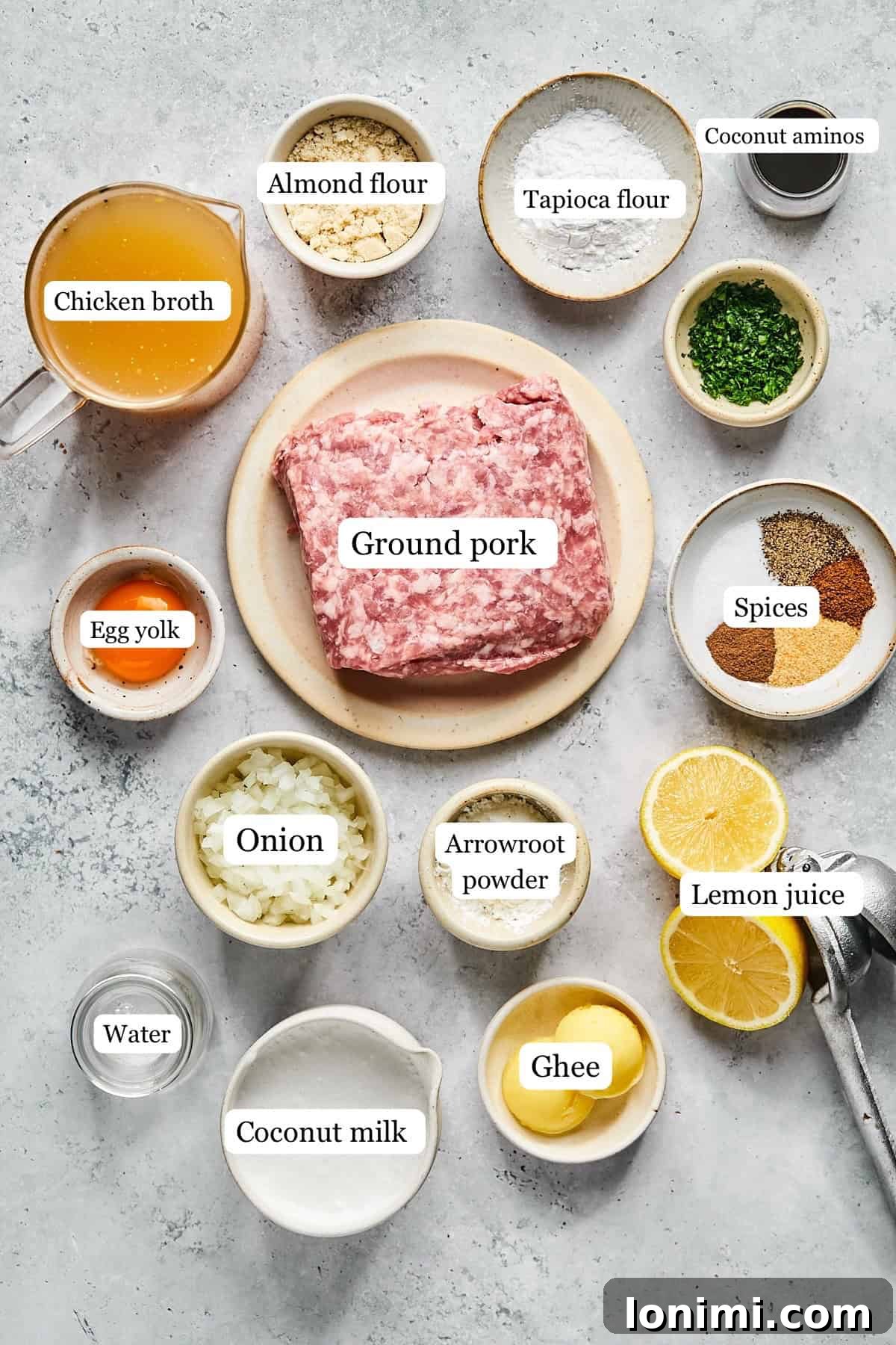 Collection of fresh ingredients for Swedish meatballs in nesting bowls, including ground pork, diced onion, and various spices.