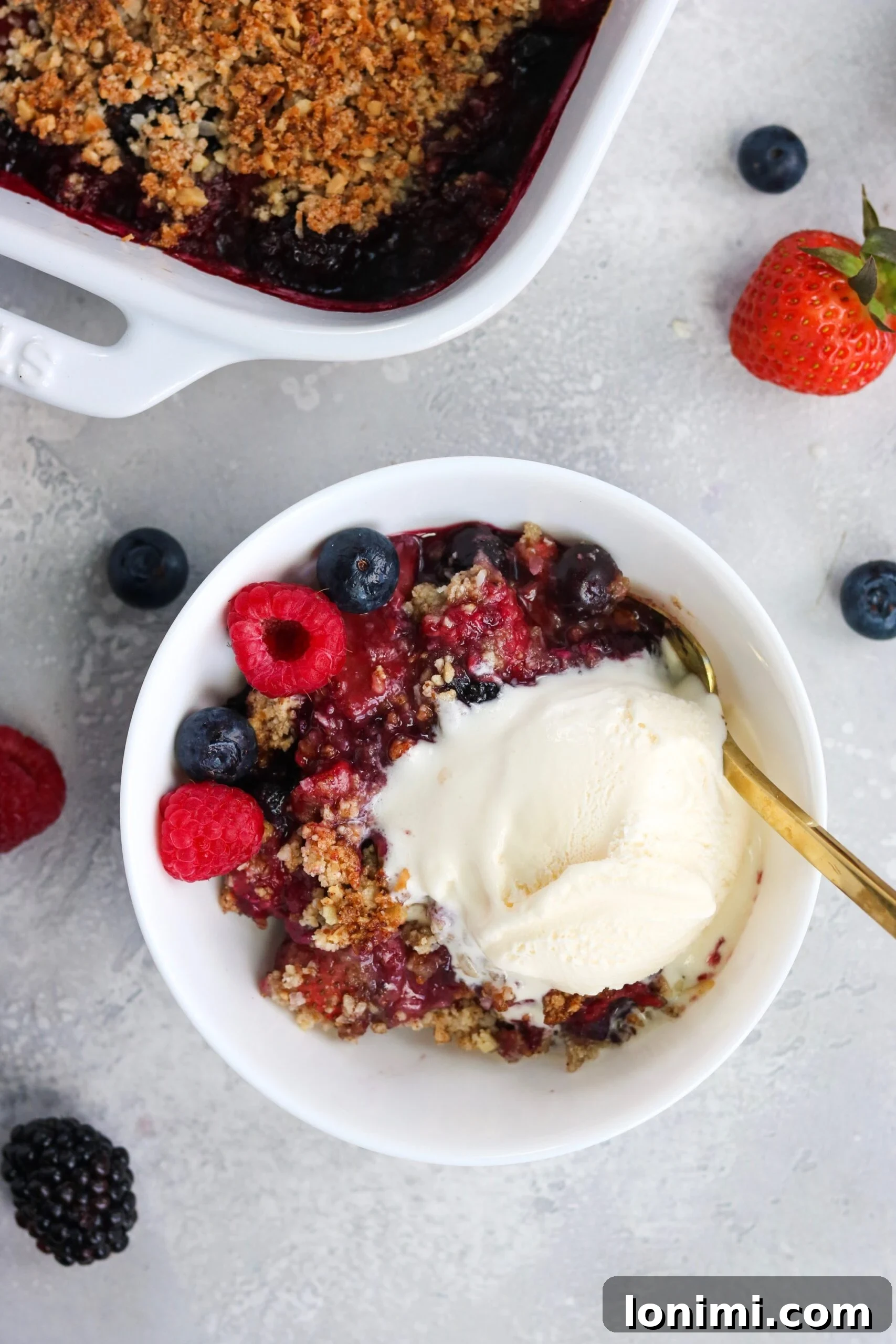 Close-up of Paleo Vegan Berry Crisp showing the golden-brown crumble topping and bubbling berry filling.