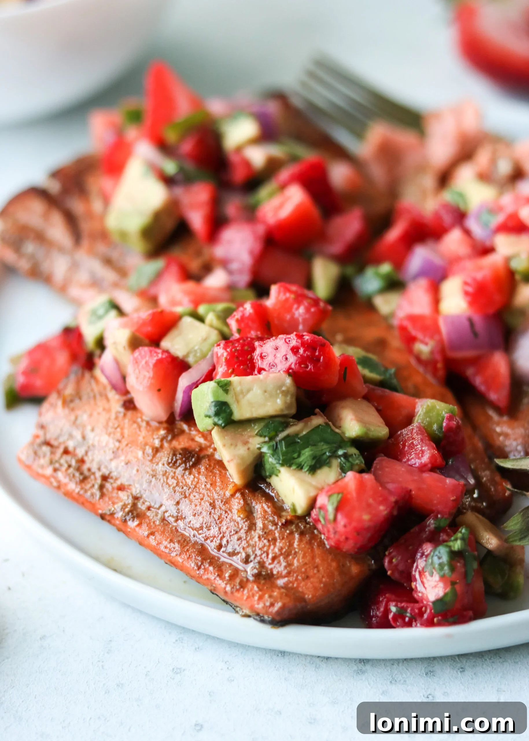 Final plated dish of Balsamic Grilled Salmon with Strawberry Avocado Salsa, overhead shot