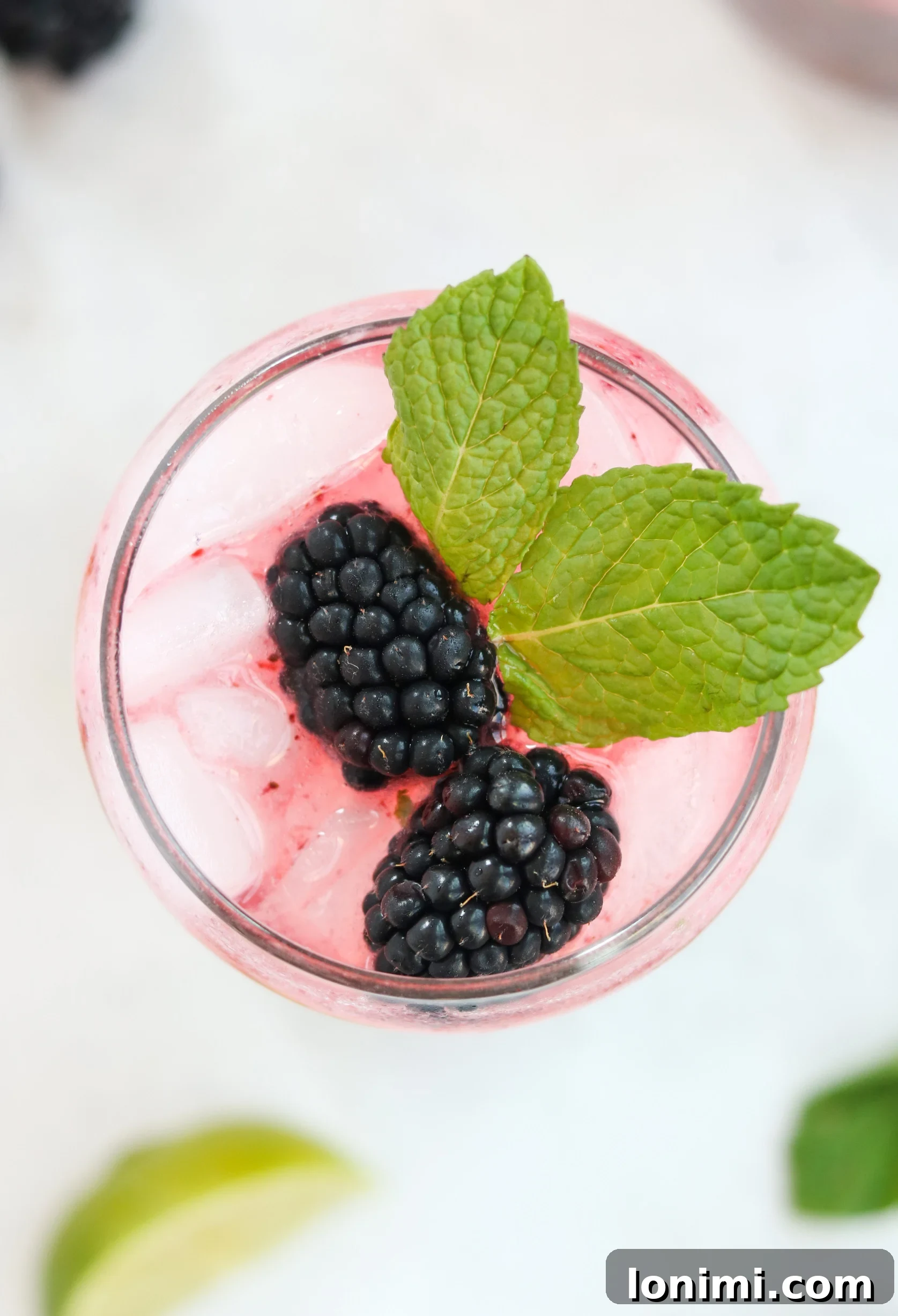 Ingredients laid out for making a Blackberry Mojito including fresh mint, limes, and blackberries