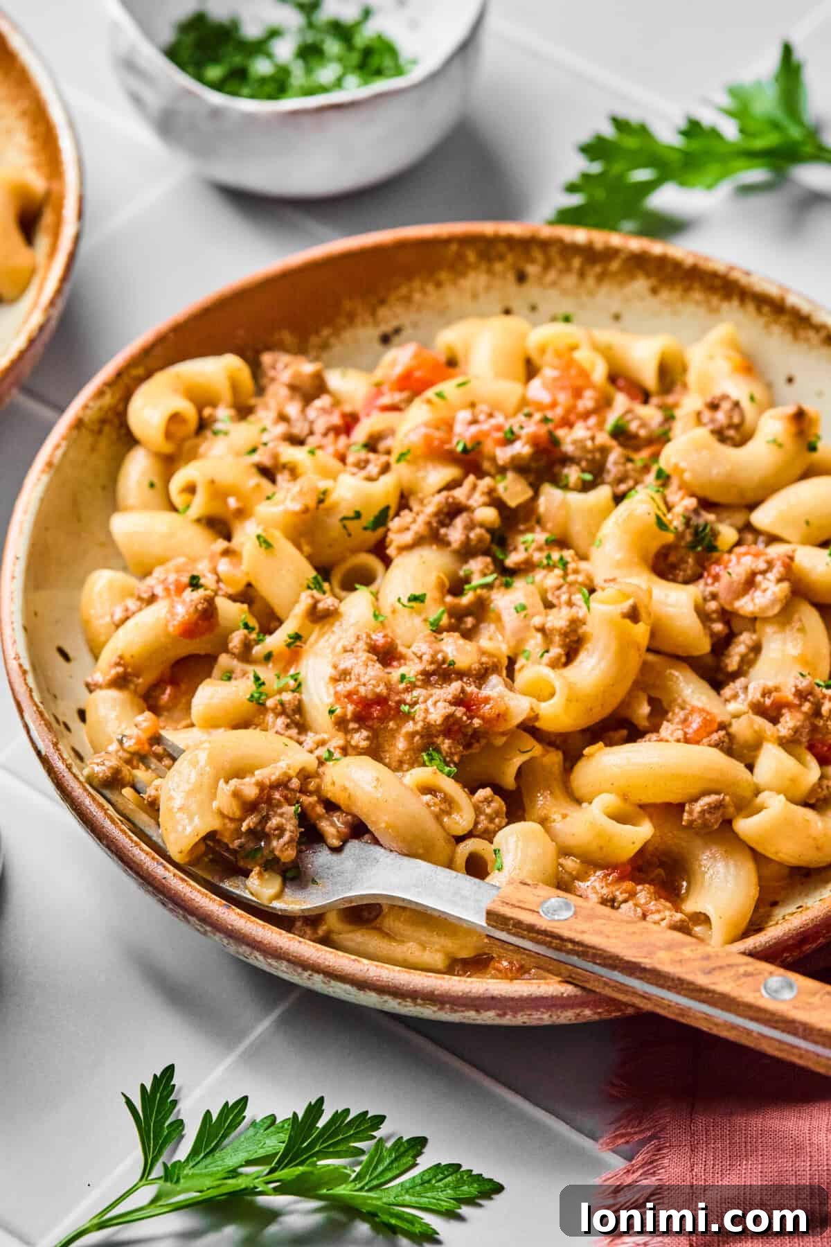 Hearty Gluten-Free Beef and Pasta Skillet Dairy-Free Option 11 A close-up side view of a generous bowl of creamy gluten-free hamburger helper, garnished with fresh herbs.