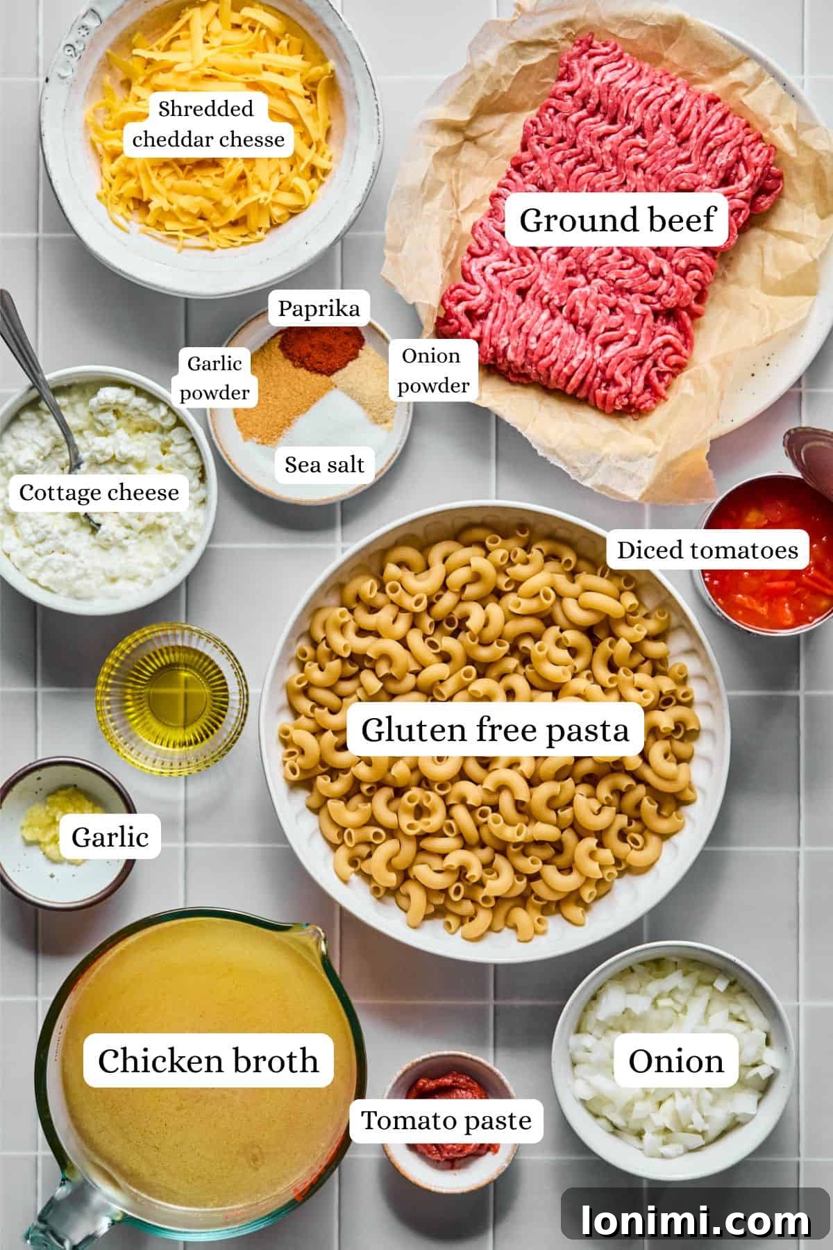 Hearty Gluten-Free Beef and Pasta Skillet Dairy-Free Option 3 A selection of fresh ingredients for hamburger helper, including ground beef, diced tomatoes, broth, spices, onion, and garlic, arranged in nesting bowls.