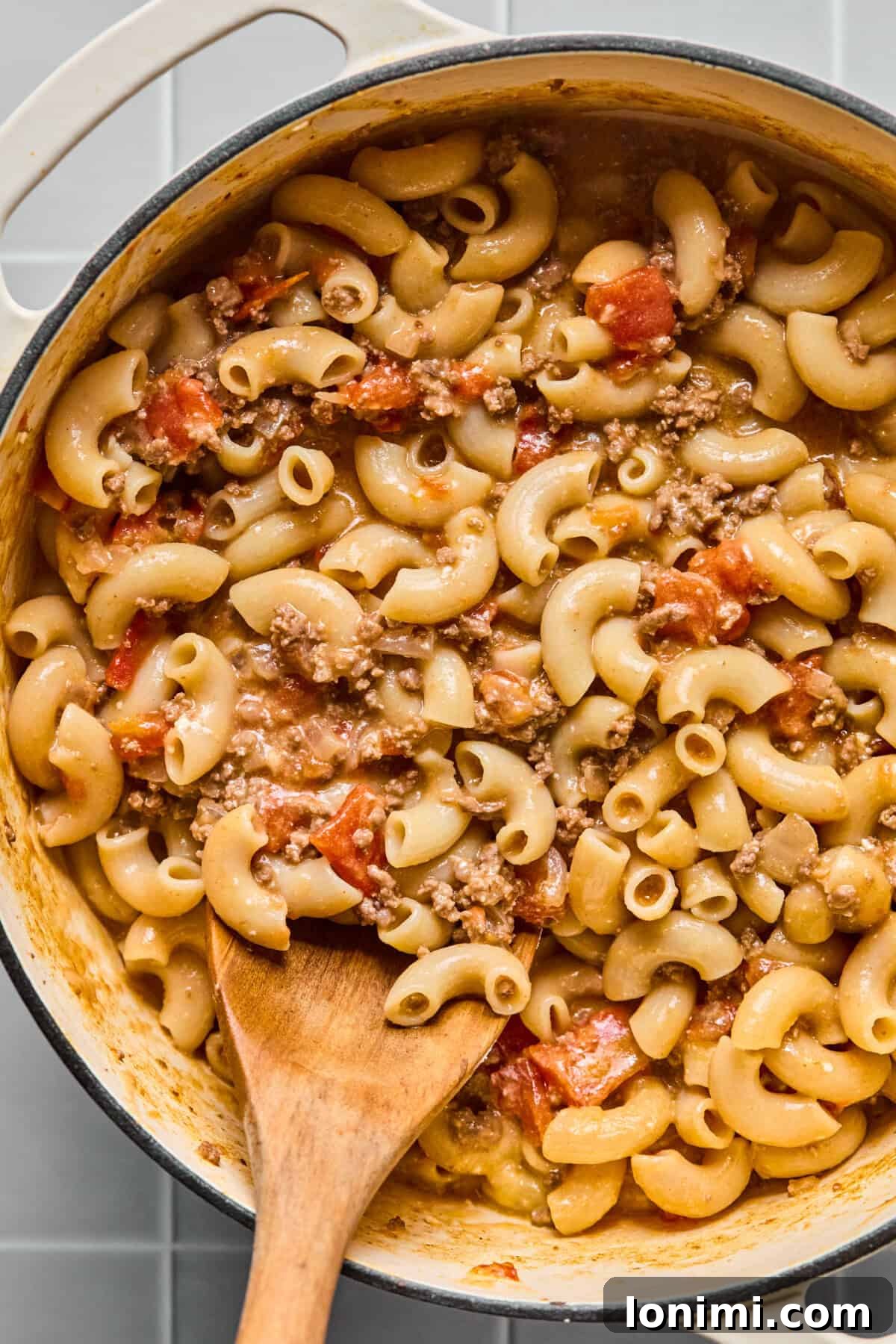Hearty Gluten-Free Beef and Pasta Skillet Dairy-Free Option 9 A large pot of finished one-pot hamburger helper, creamy and ready to serve, with a wooden spoon resting inside.