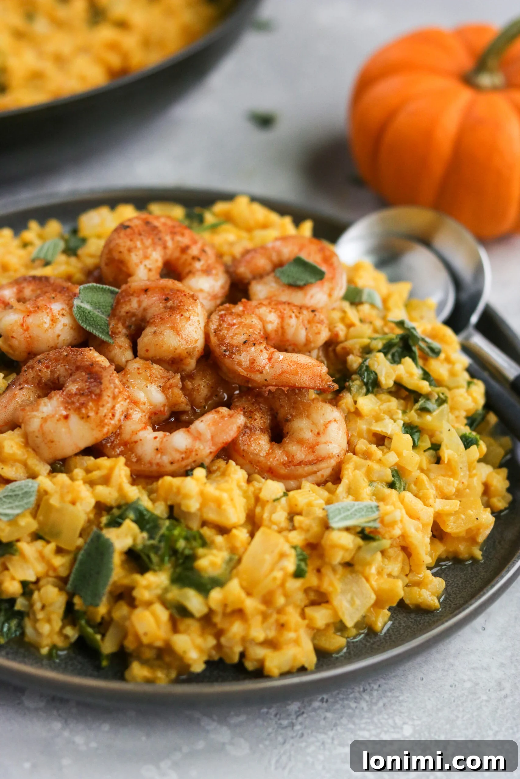 Cooked Whole30 Pumpkin Risotto in a serving bowl with a spoon, ready to be enjoyed