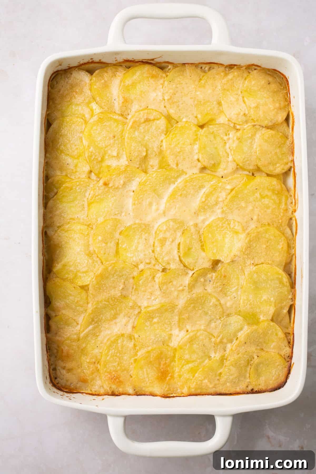 an overhead shot of gluten free scalloped potatoes in a white baking dish. 