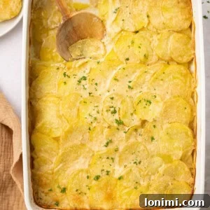 gluten free scalloped potatoes in a casserole dish with a wooden spoon taking a scoop out
