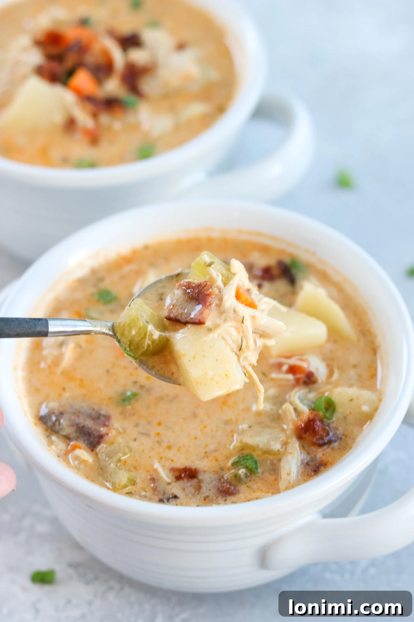 Spicy Buffalo Chicken Chowder 5 Two bowls of Whole30 Buffalo Ranch Chicken Chowder on a rustic table