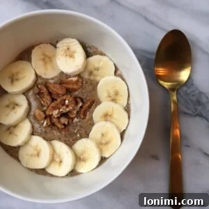 A top-down view of a small bowl filled with creamy warm pumpkin spice chia pudding, garnished with a sprinkle of pumpkin pie spice.