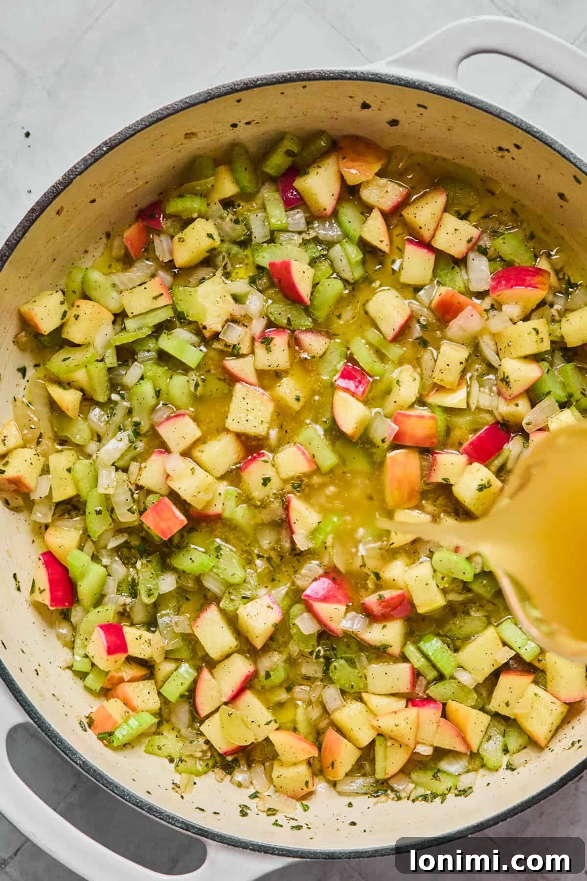 apples, celery, herbs and broth in a skillet