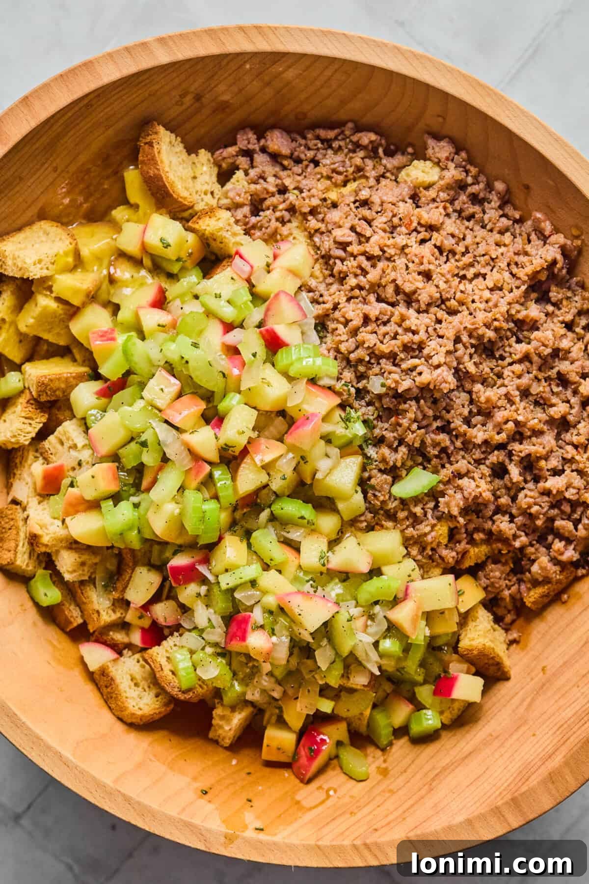bread, sausage, and apples and herbs in a bowl